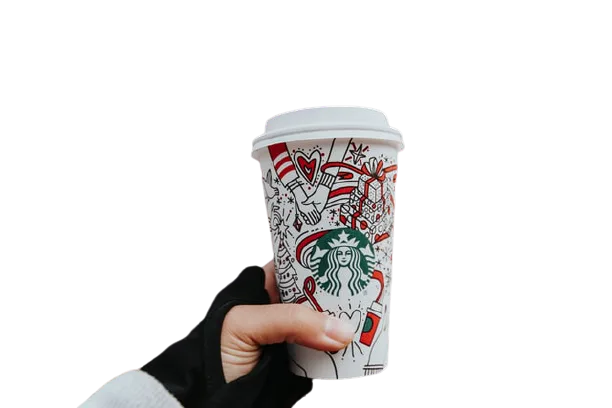 Hand holding a Starbucks paper cup with a festive red and white illustrated design